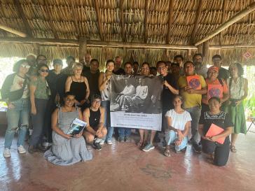 Les descendants des guerriers de caste tiennent une bannière avec une photo d'Evaristo Sulub. Texte ci-dessous : "13 avril 1933 - Défense des Mayas máasewáal contre l'armée d'invasion mexicaine dans la municipalité de Dzulá - à la mémoire de nos grands-pères et grands-mères"